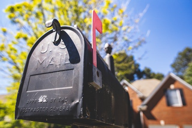 Black Metal Mailbox With A Red Flag Signaling Mail Has Been Delivered