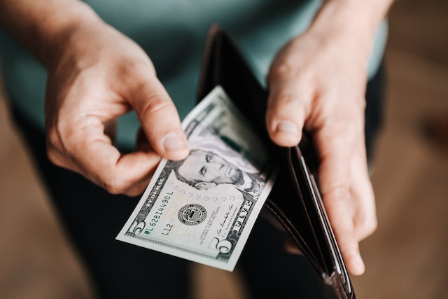 A-Person-Taking-Money-Out-Of-Their-Wallet