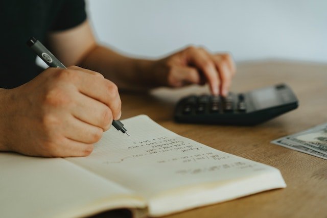 Person Using A Calculator To Balance A Budget